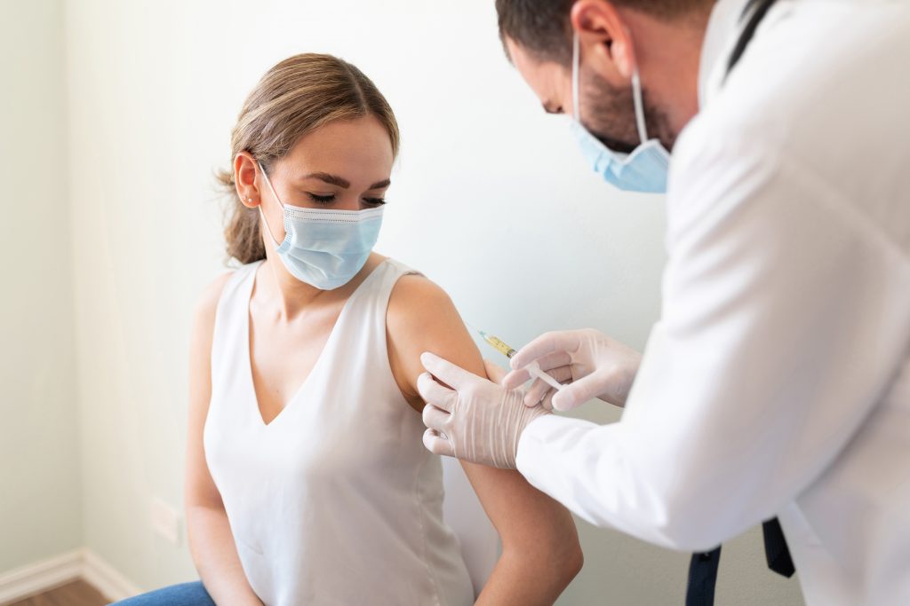 Doctor applying a vaccine on a woman's arm