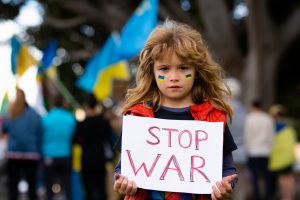 Kids with poster with banner of russia conflict, military protest. Child with message Stop War. America stand with Ukraine