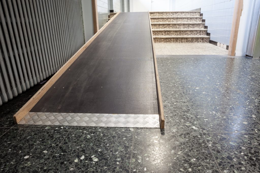 next to the stairs, there is a wooden bridge for wheelchair users