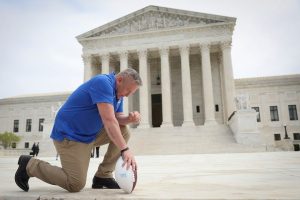 Former Bremerton High School assistant football coach Joe Kennedy takes a knee in front of the U.S. Supreme Court after his legal case, Kennedy vs. Bremerton School District, was argued before the court on April 25, 2022 in Washington, DC. Kennedy was terminated from his job by Bremerton public school officials in 2015 after refusing to stop his on-field prayers after football games. (Photo by Win McNamee/Getty Images) Former Bremerton High School assistant football coach Joe Kennedy takes a knee in front of the U.S. Supreme Court after his legal case, Kennedy vs. Bremerton School District, was argued before the court on April 25, 2022 in Washington, DC. Kennedy was terminated from his job by Bremerton public school officials in 2015 after refusing to stop his on-field prayers after football games.