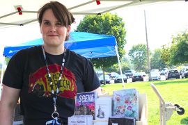 Festival organizer and founder Dani Gray poses in front of her booth with several zines on display during the first-ever Bremerton Zine Fest. Photo by Kitsap Scene. Bremerton Zine & Small Press Festival organizer and founder Dani Gray poses in front of her booth with several zines on display. Photo by Kitsap Scene.