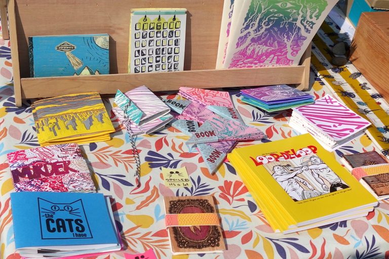 A display of zines at a booth at the Bremerton Zine & Small Press Festival