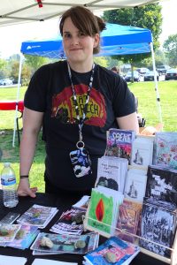 Dani Gray, founder and organizer of the Bremerton Zine & Small Press Festival, stands at her booth with a wealth of zines on display