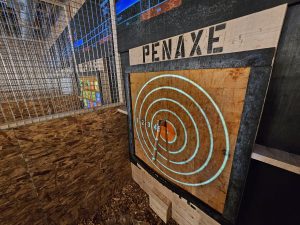 An axe sunk into a wooden target at PenAxe in Port Orchard WA. Photo courtesy of PenAxe