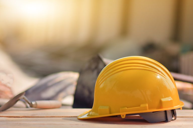 Yellow helmet hard hat on wood floor in constriction site