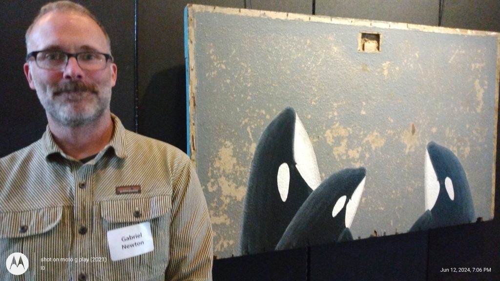 Artist Gabriel Newton used acrylic on found wood to paint Southern Resident orcas, which feed in the Salish Sea.